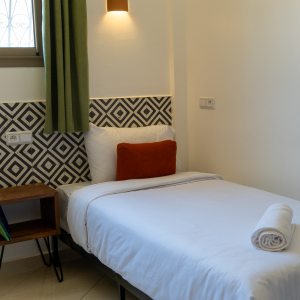 twin room Les Terrasses Hostel tamraght Morocco Bright twin room with two single beds and shared bathroom at Les Terrasses Hostel, Tamraght, offering a clean and cozy atmosphere for friends or solo travelers.